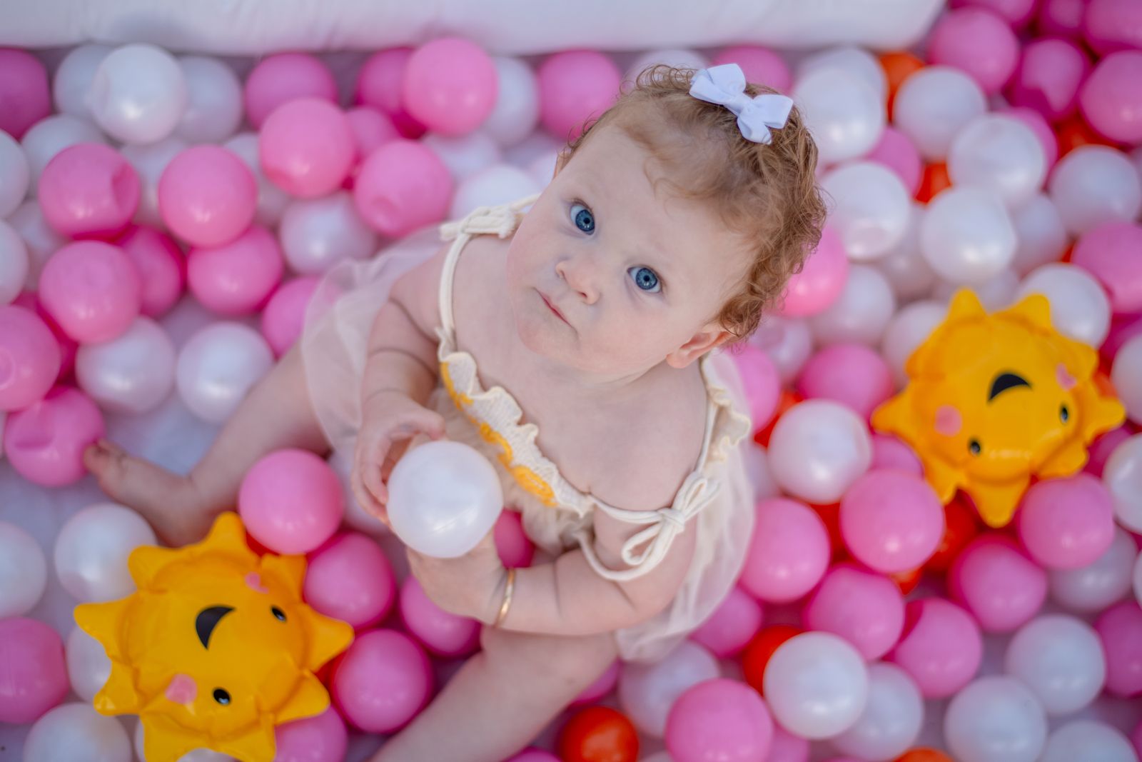 Baby playing in a pastel ball pit