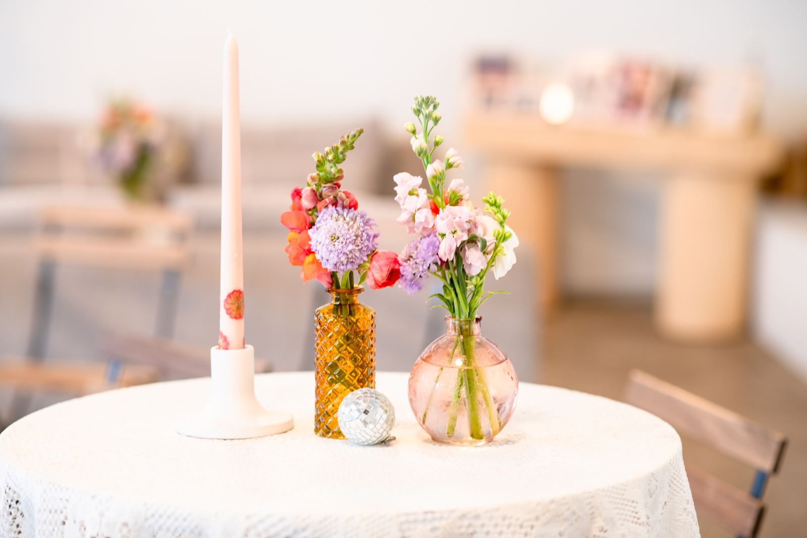 Bud vases and taper candles down a lace table