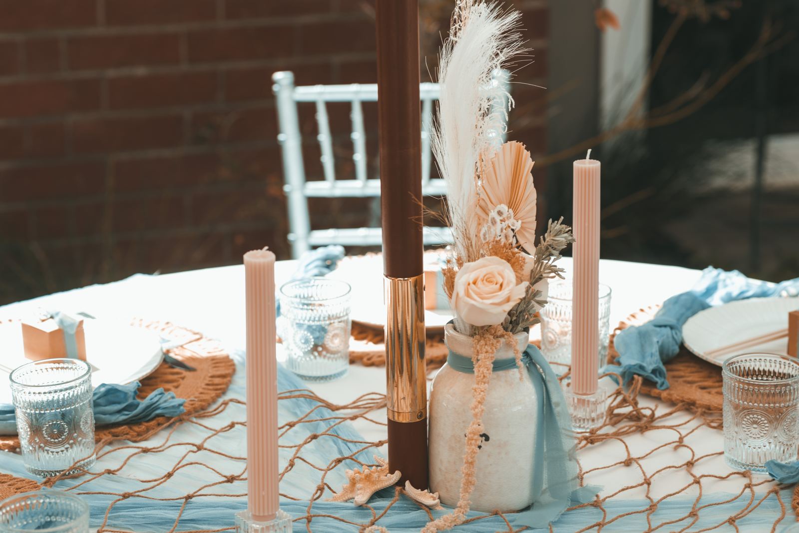 Coastal blue sweetheart table with netting and candles