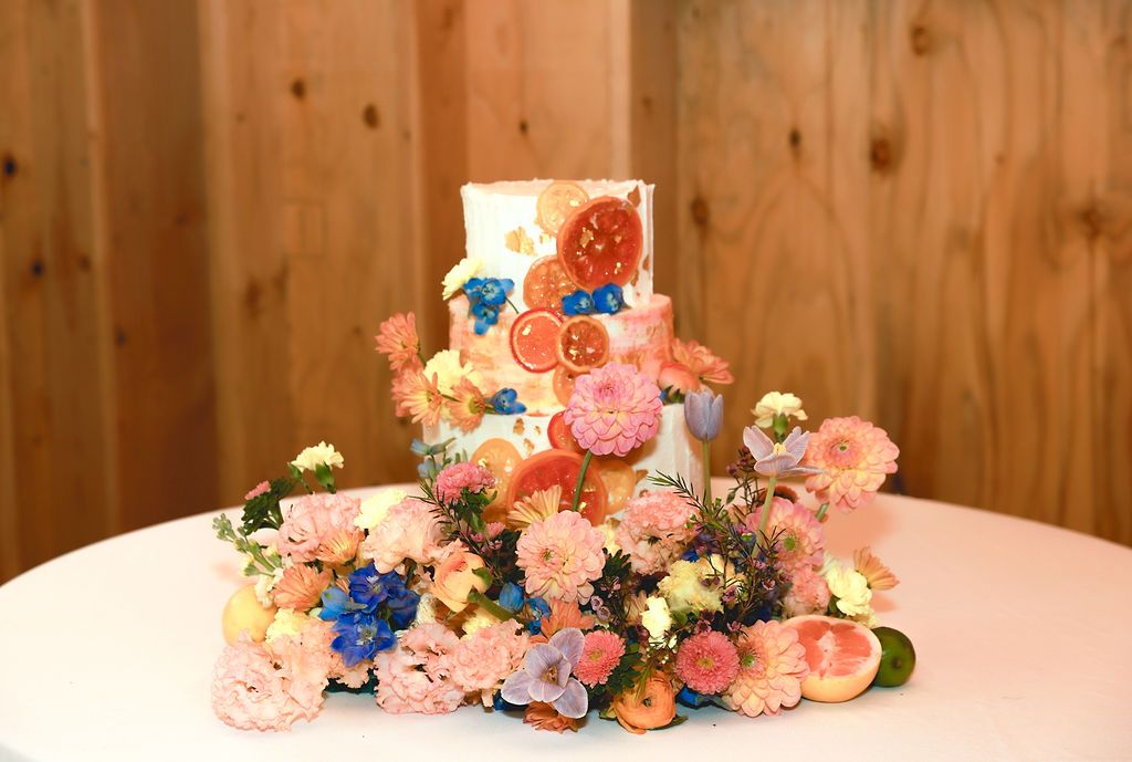 Colorful wedding cake covered in fresh flowers