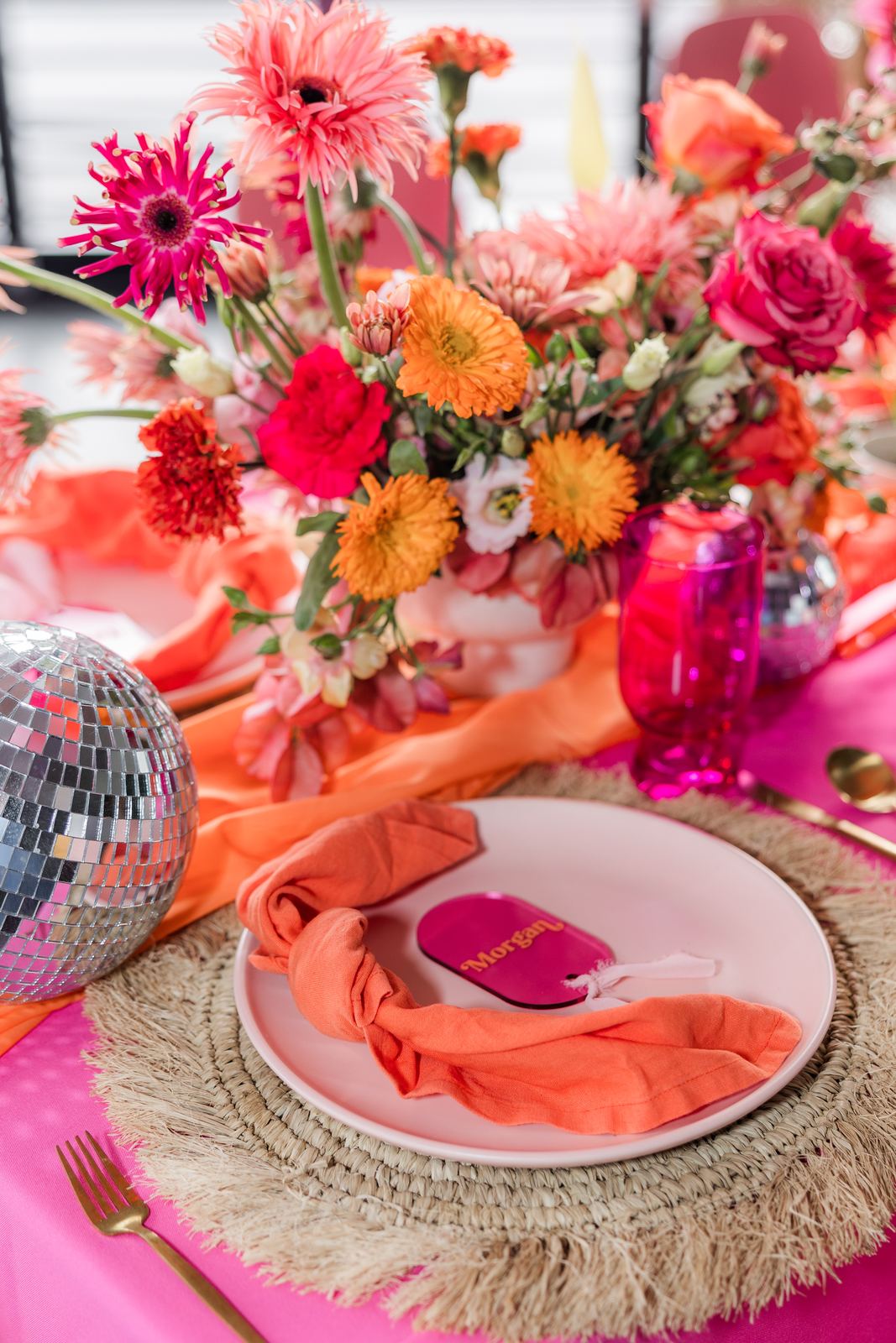 Pink and orange tablescape with a disco ball centerpiece