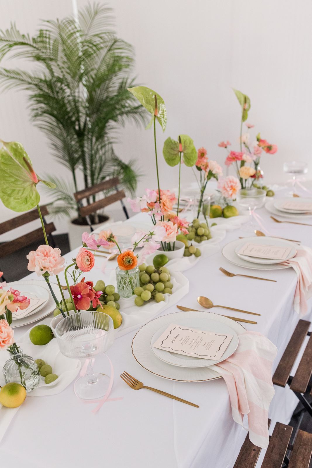 Long white table with greenery and taper candles