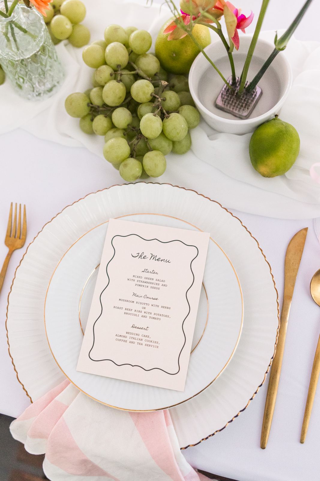 Place setting with a printed menu, citrus and gold flatware