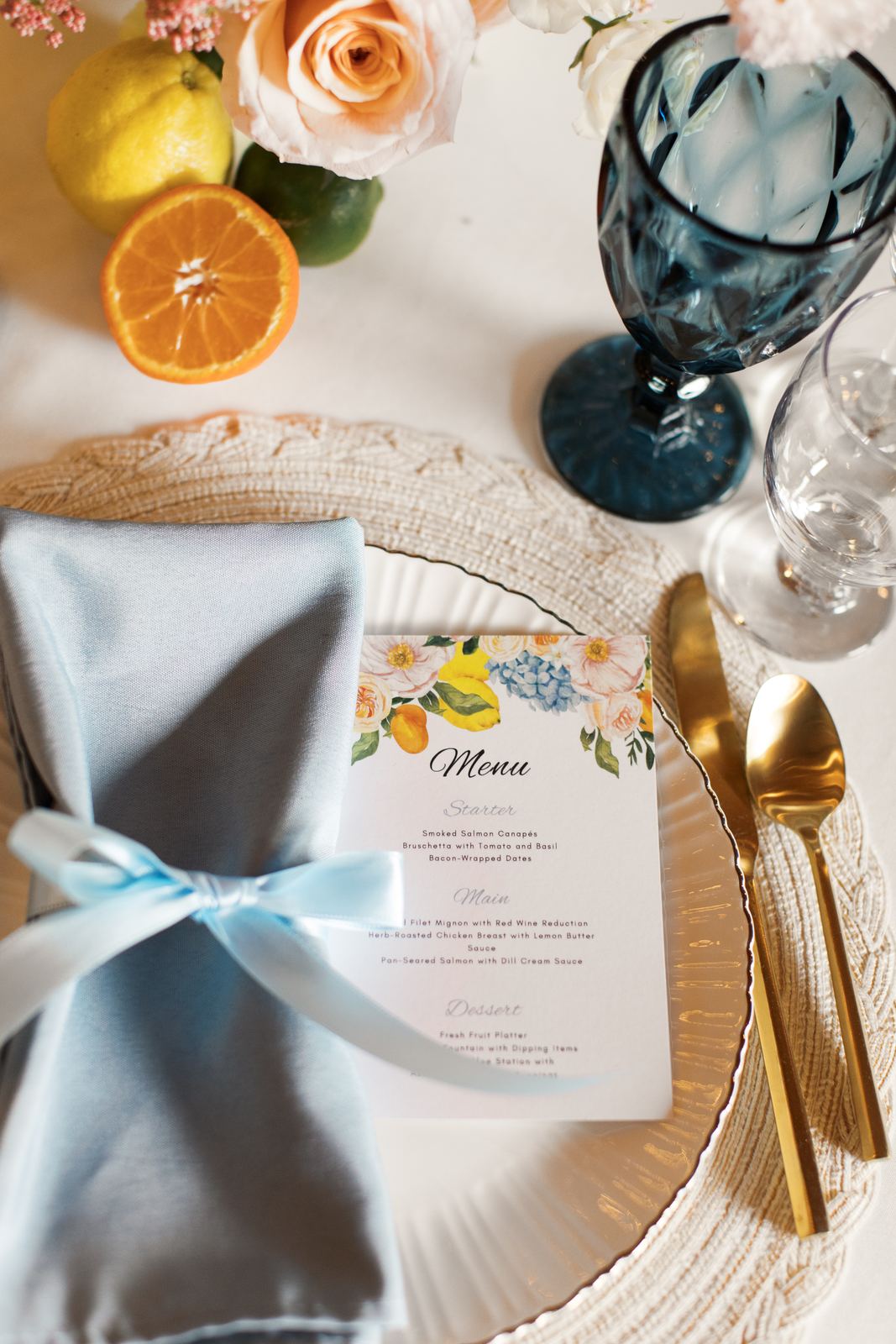 Place setting with a dusty blue napkin and citrus menu