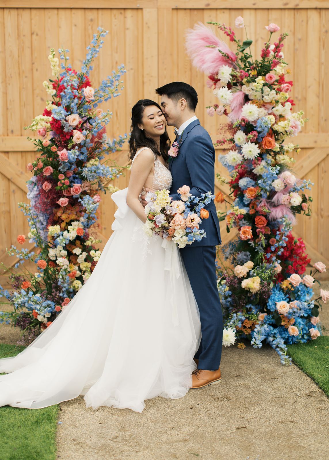 Couple standing between tall colorful floral columns