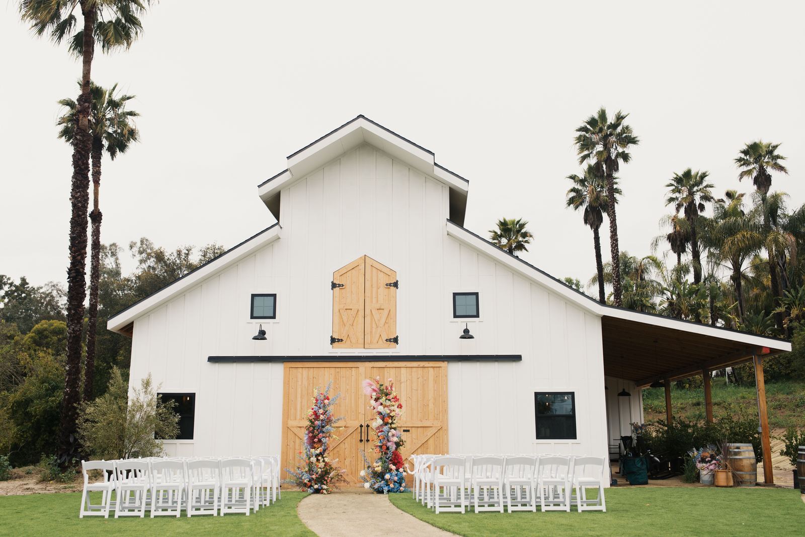 White barn wedding venue with ceremony chairs lined up