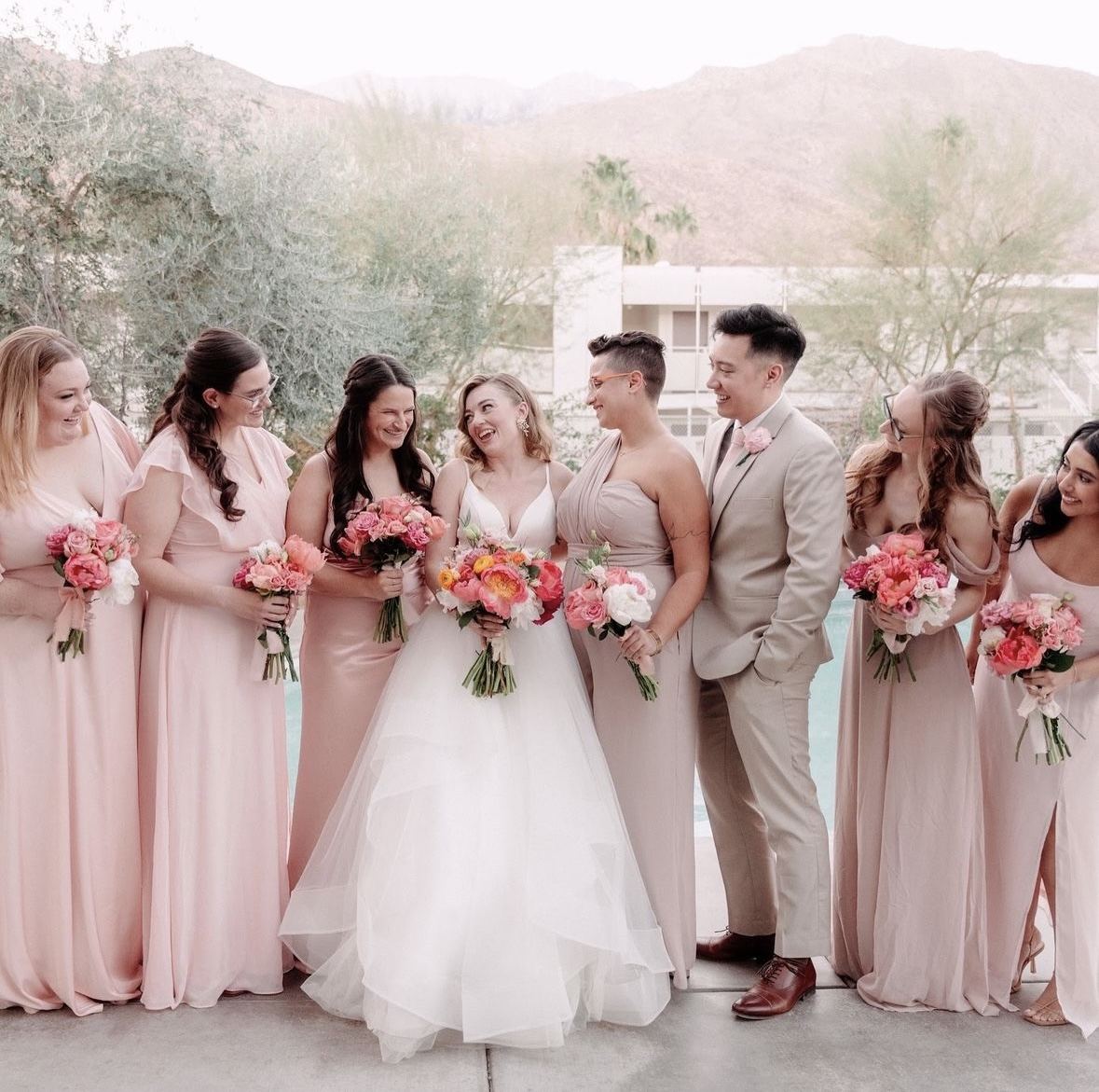 Bridal party in blush holding fresh bouquets