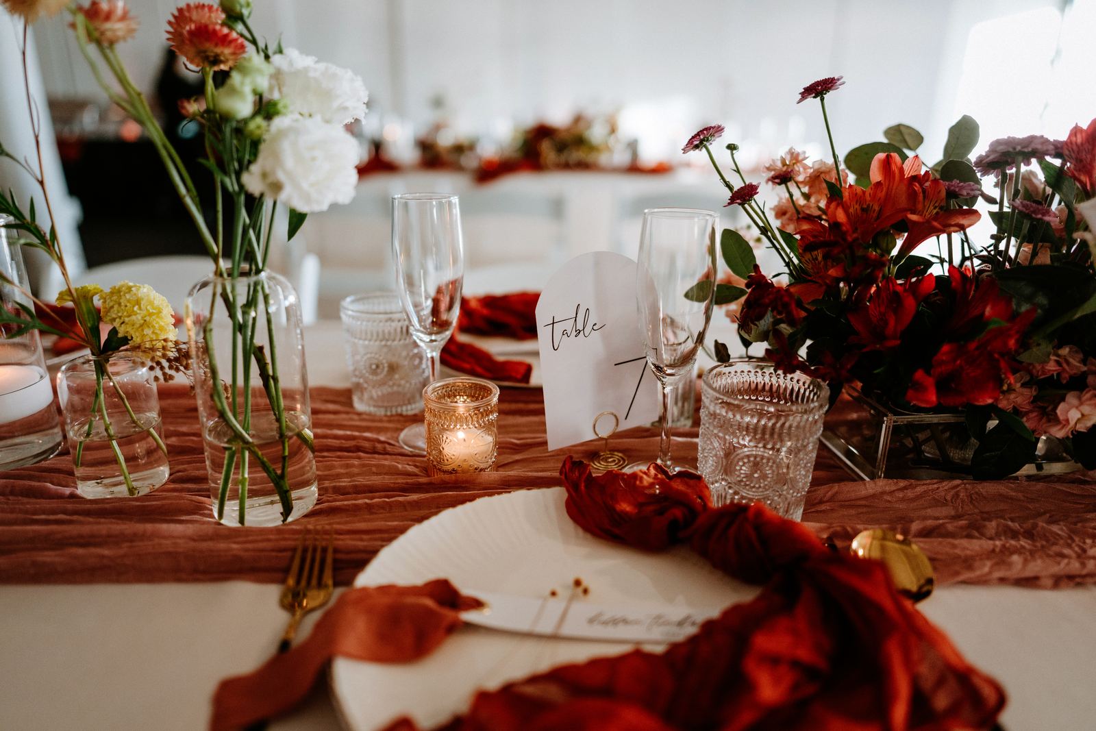 Reception tables with deep red floral centerpieces