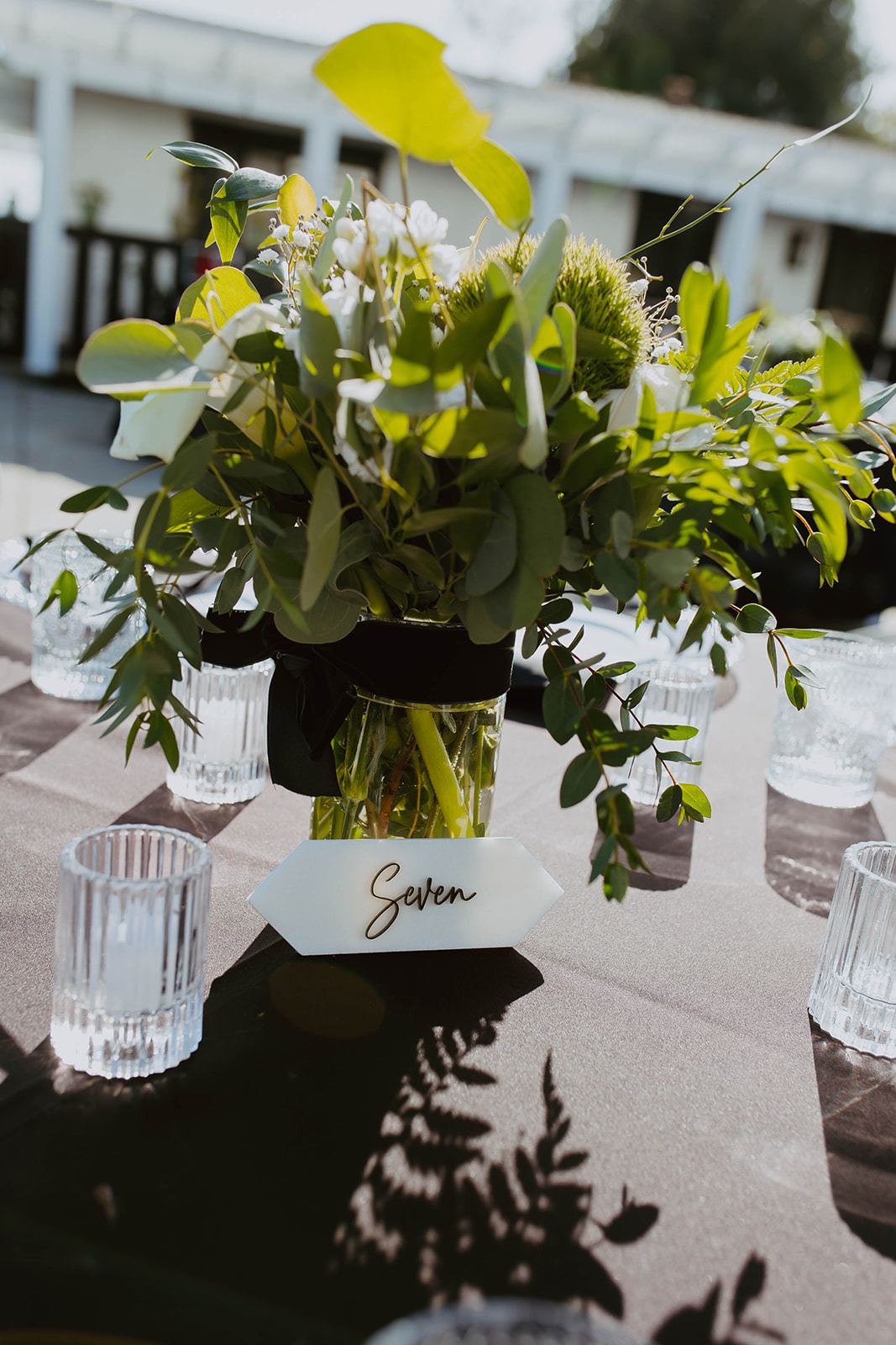 Green and white place settings with bud vases
