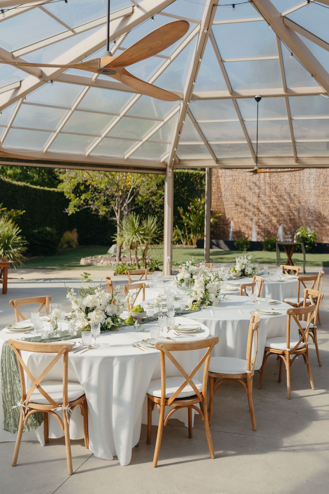 Reception tables set under a glass roof