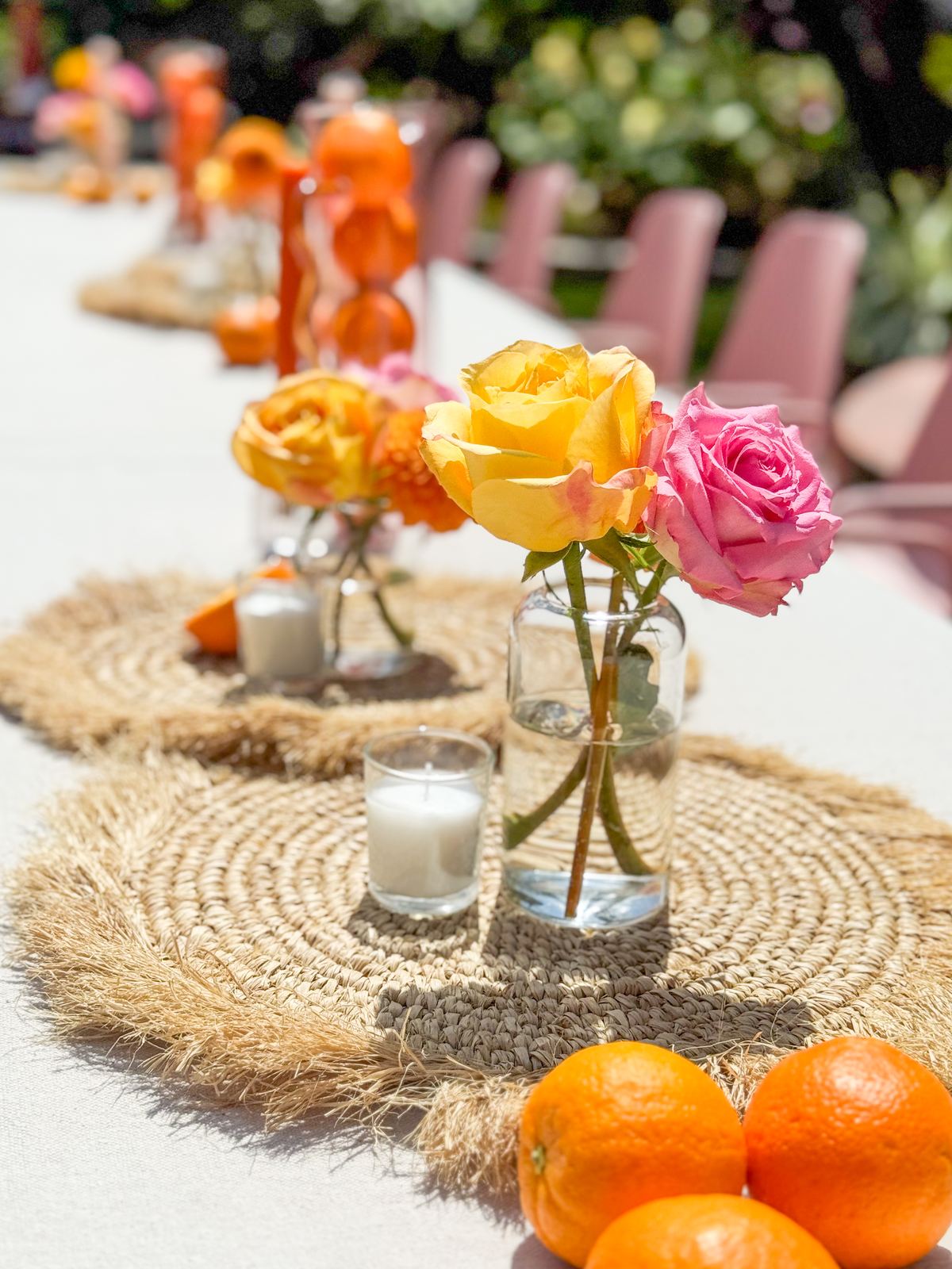 Roses and candles styled on a woven table runner