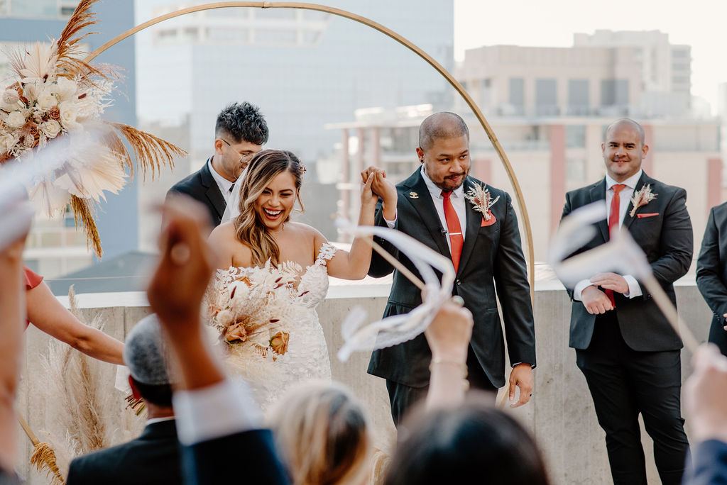 Rooftop ceremony with a floral hoop over the city