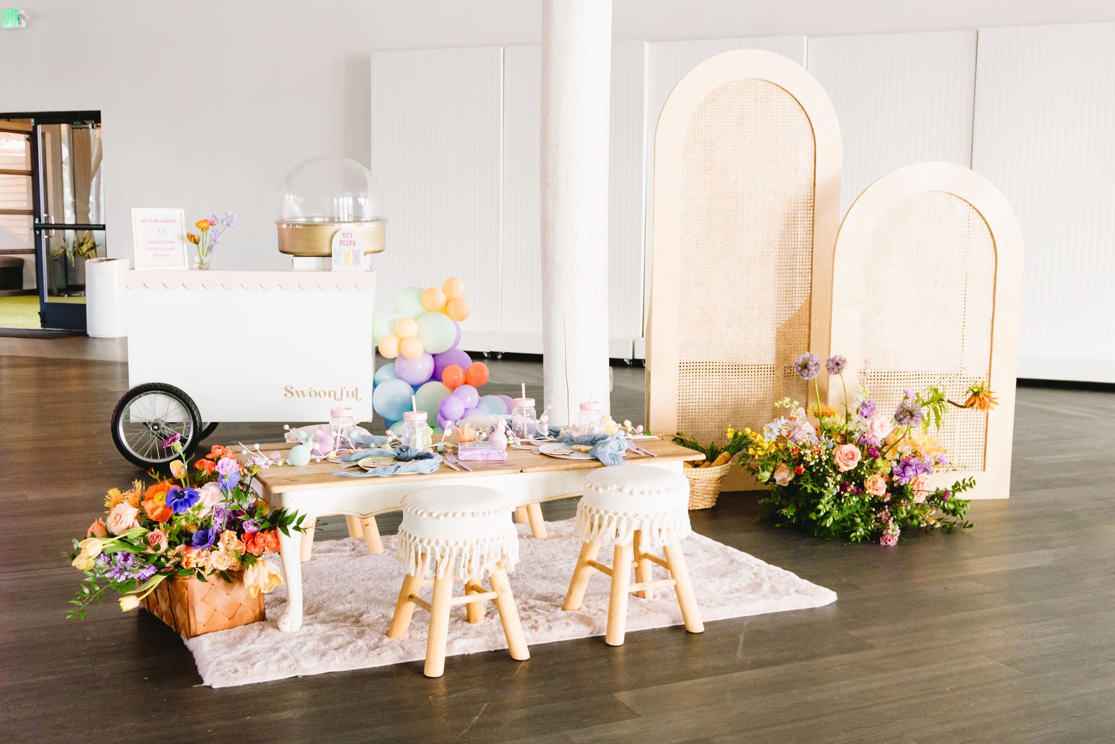 Pastel kids party with arch backdrops, florals and a picnic table